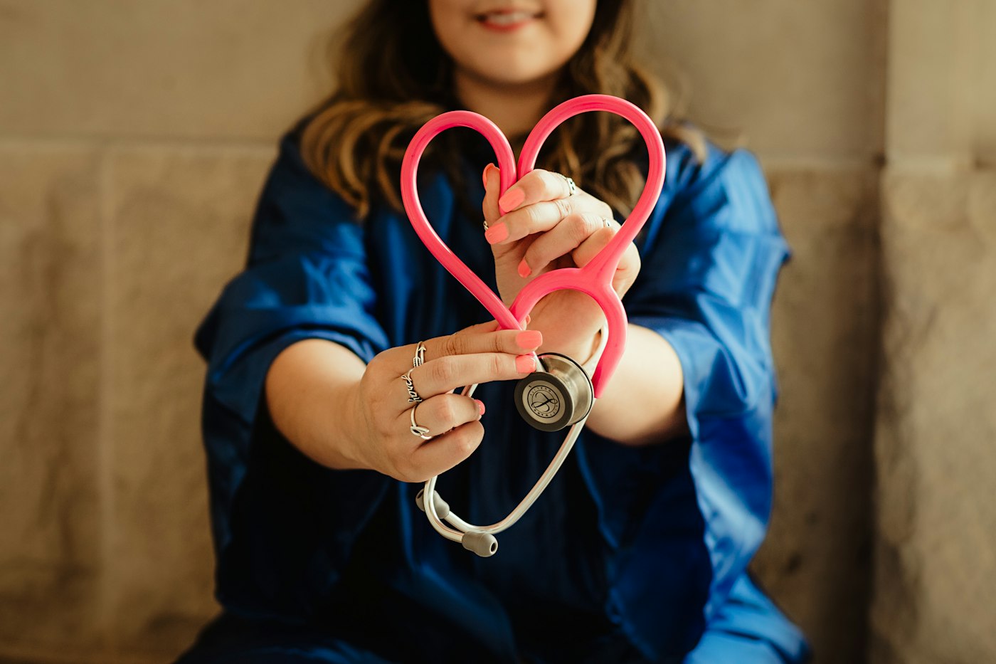 A student in scrubs holding a stethoscope